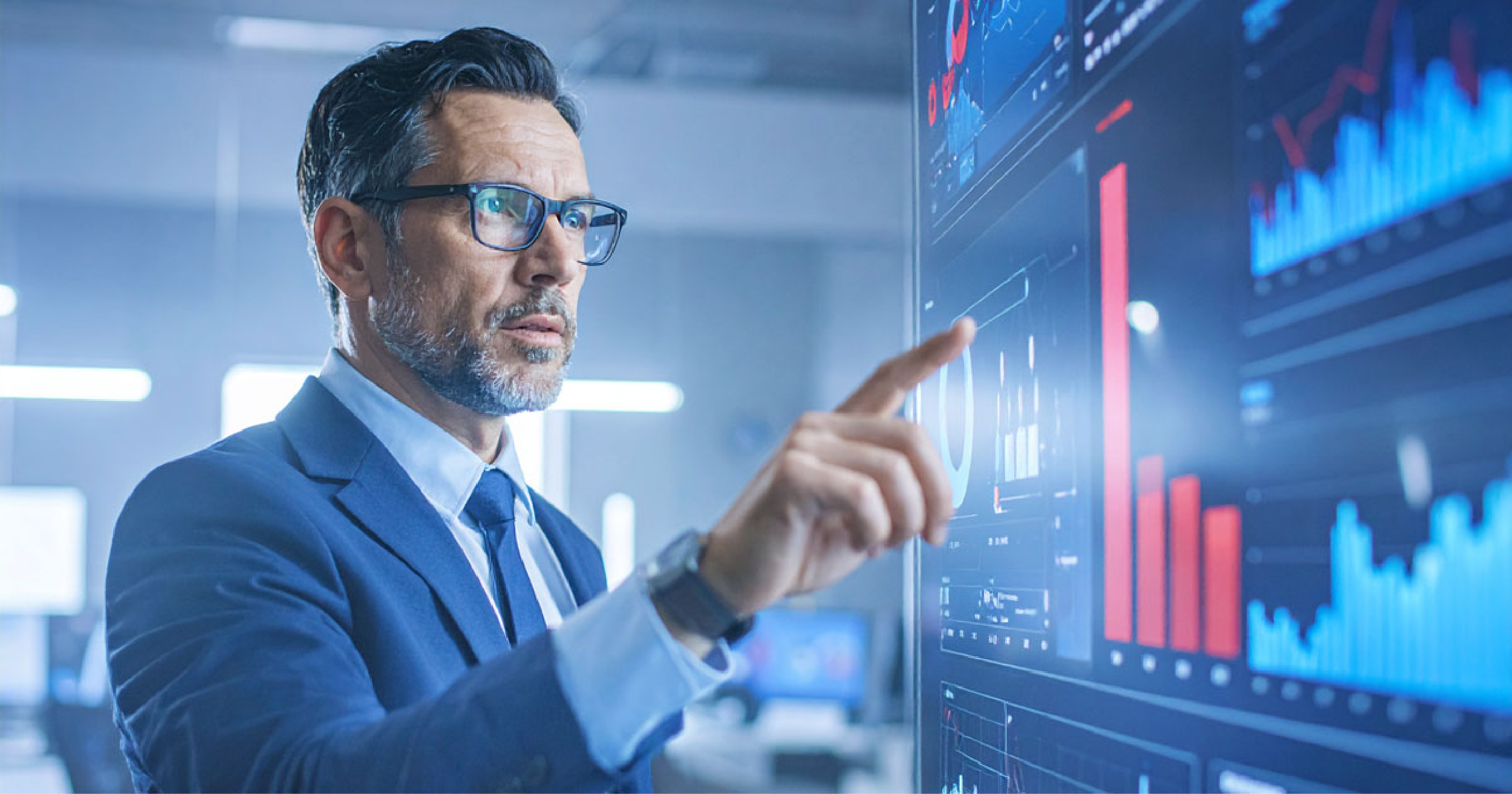 A photo of a man in front of a screen with graphs